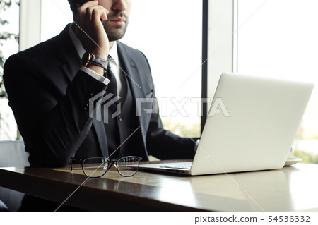 Close up of handsome businessman, working on laptop in restaurant Close up of handsome businessman, working on laptop in restaurant 54536332