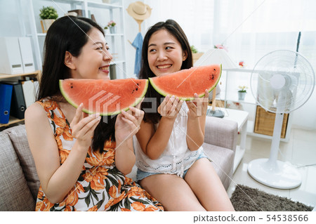 two girls looking each other having fruit 54538566