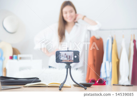woman blogger showing clothes in front of camera woman blogger showing clothes in front of camera 54539085