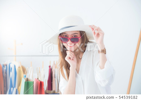 Beautiful asian woman trying sunglasses and hat  54539182
