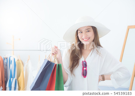 Beautiful asian woman holding shopping bags  54539183