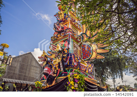 Bade cremation tower with traditional balinese sculptures of demons and flowers on central street in Bade cremation tower with traditional balinese sculptures of demons and flowers on central street in 54542091