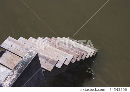 Wooden stairs on the way down the river or canal Wooden stairs on the way down the river or canal 54543306