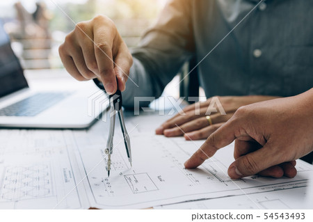 Architect working on blueprint in workplace with 54543493