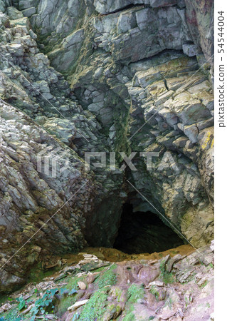 Limestone cliff wall with entrance of the cave. Limestone cliff wall with entrance of the cave. 54544004