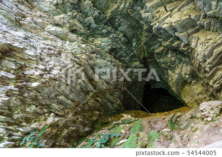 Limestone cliff wall with entrance of the cave. 54544005