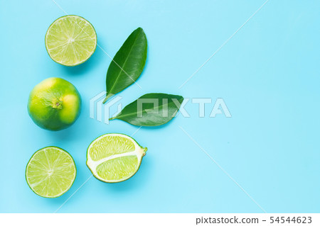Limes with leaves on blue background. Limes with leaves on blue background. 54544623