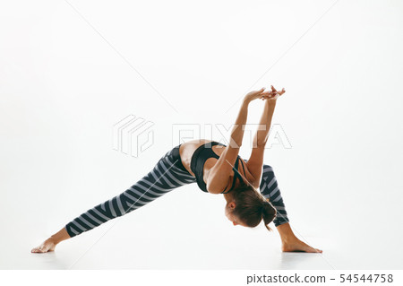 Sporty young woman doing yoga practice isolated on white background 54544758