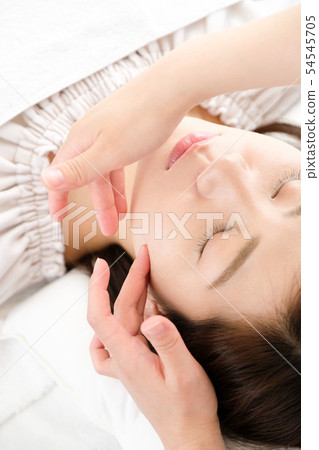 Hand of woman and practitioner who receive face massage 54545705