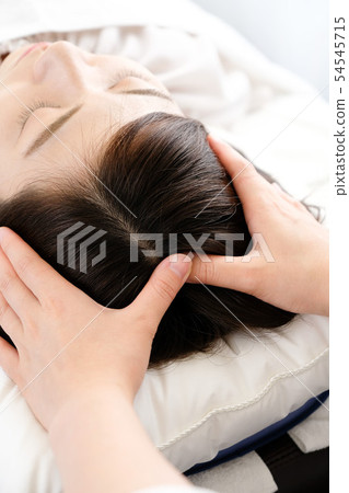 接受頭皮按摩的女性和實習者手 接受頭皮按摩的女性和實習者手 54545715