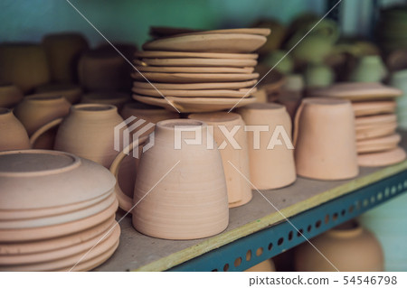 Cups on the shelves in the pottery workshop 54546798