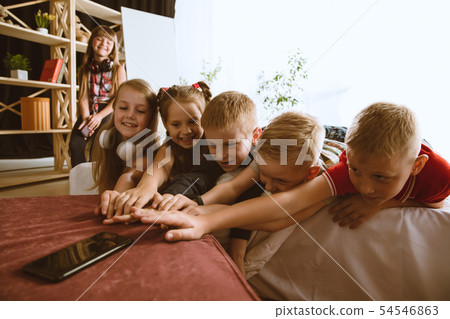 Little boys and girls using different gadgets at home Little boys and girls using different gadgets at home 54546863