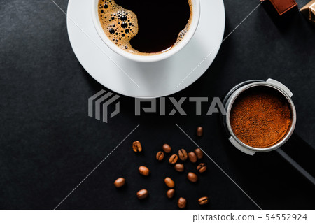 Tasty coffee on the black table with chocolate. 54552924