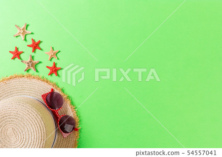 Beach hat with seashells on brown green table. Beach hat with seashells on brown green table. 54557041