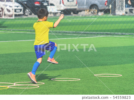 Child with soccer boots training on agility speed Child with soccer boots training on agility speed 54559823