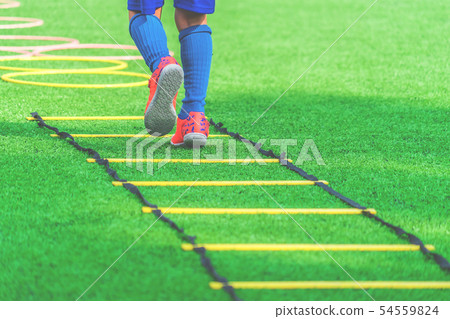 Child feet with soccer boots training on agility Child feet with soccer boots training on agility 54559824