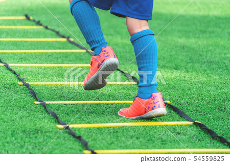 Child feet with soccer boots training on agility 54559825