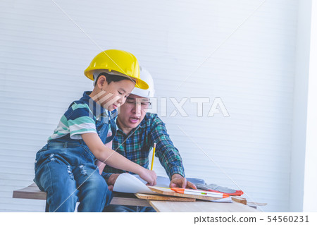 Builder Father is teaching his son to read the 54560231