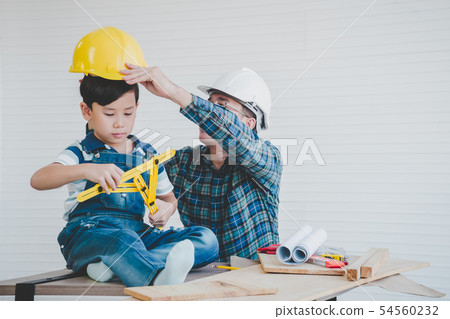 Engineer Father is placing safety hat for his son Engineer Father is placing safety hat for his son 54560232