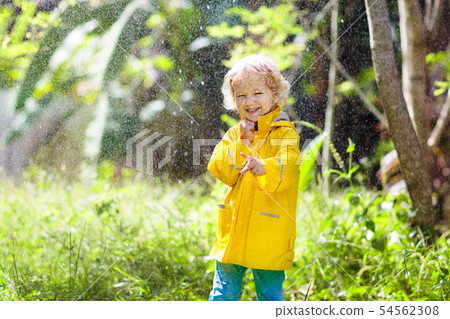 Child playing in the rain. Kid with umbrella. Child playing in the rain. Kid with umbrella. 54562308