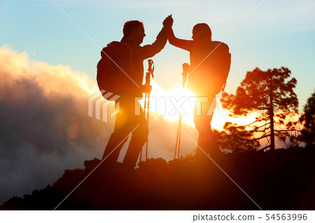 Hiking people reaching summit top high five 54563996