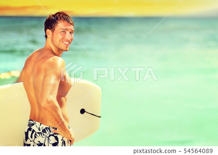 Surfer man going surfing on summer beach 54564089