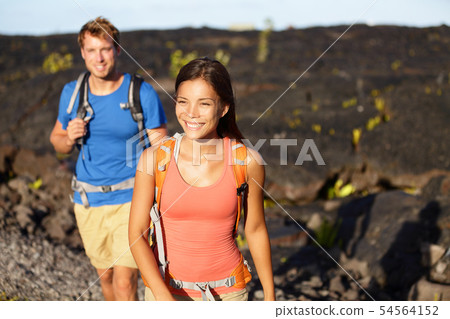 Hiking people - couple walking on lava field Hiking people - couple walking on lava field 54564152