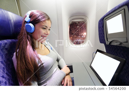 Plane passenger in airplane using tablet computer 54564200