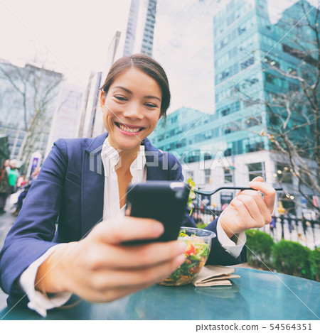Young business woman on smartphone in lunch break Young business woman on smartphone in lunch break 54564351