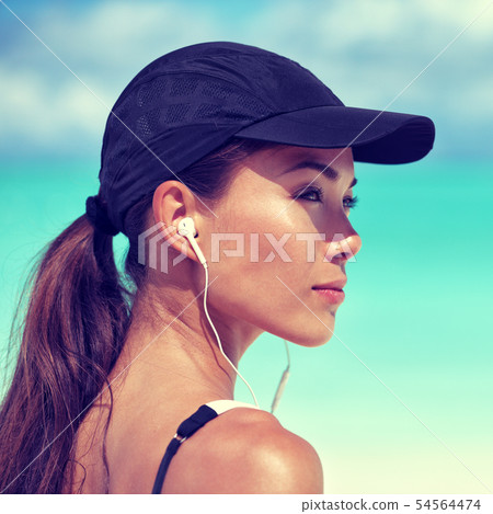 Fitness runner woman listening to music on beach Fitness runner woman listening to music on beach 54564474