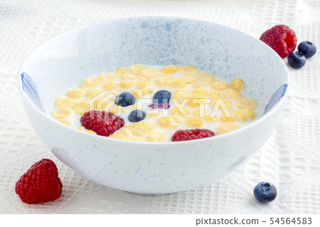 Berries in bowl full of cornflakes and milk for br 54564583