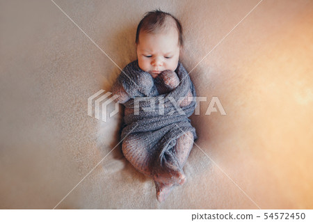 newborn baby sleeps wrapped in a blanket 54572450