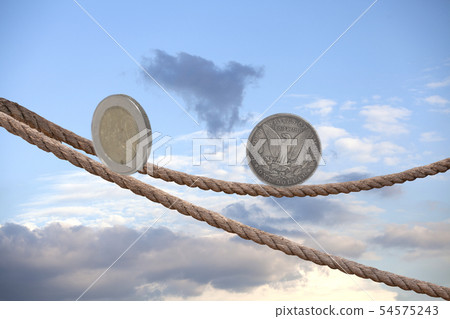 2 Euro coin and one dollar coin balancing on rope 2 Euro coin and one dollar coin balancing on rope 54575243