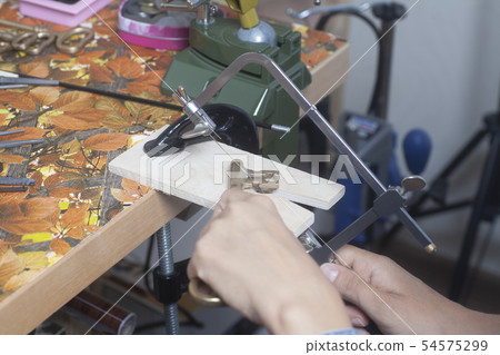 Jeweler working with jewerly saw. Jeweler working with jewerly saw. 54575299