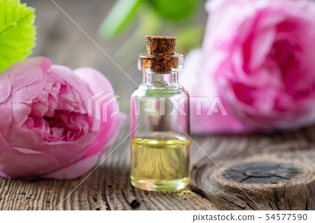 A bottle of rose essential oil with cabbage roses A bottle of rose essential oil with cabbage roses 54577590