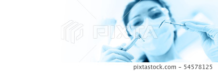 Dentist in mask holding angled mirror and drill Dentist in mask holding angled mirror and drill 54578125