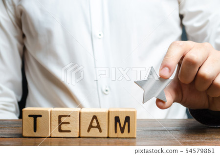 Businessman hands a star to the team word Businessman hands a star to the team word 54579861