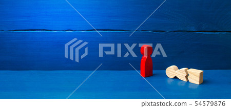 A figurine of a red man stands over a fallen split A figurine of a red man stands over a fallen split 54579876