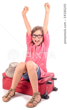 girl sitting on a suitcase is happy to go on 54580205