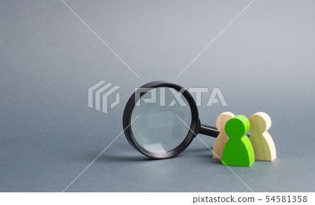 Three wooden human figure near a magnifying glass 54581358
