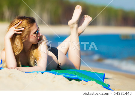 Summer vacation Girl in bikini sunbathing on beach Summer vacation Girl in bikini sunbathing on beach 54581443
