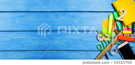 A pile of school supplies on a blue wooden table 54581709