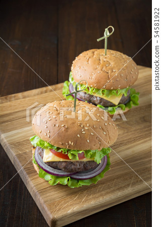 Fresh two beef burgers with vegetables on board 54581922