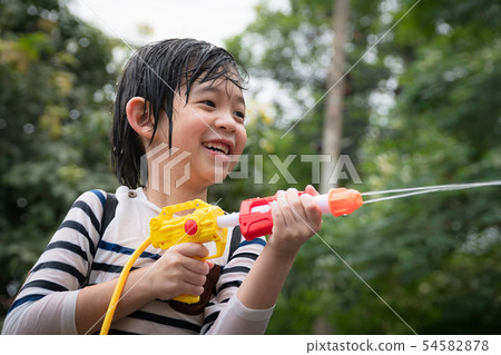 Cute Asian child playing with water gun Cute Asian child playing with water gun 54582878