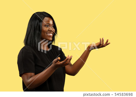 Young african woman isolated on yellow studio background, facial expression Young african woman isolated on yellow studio background, facial expression 54583698