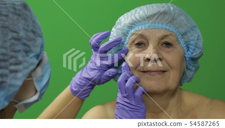 Smiling elderly female in protective hat. Plastic 54587265