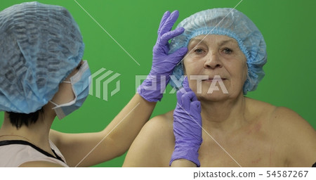 Smiling elderly female in protective hat. Plastic Smiling elderly female in protective hat. Plastic 54587267