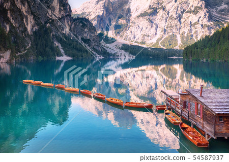 Wooden boats in a row on summer morning at Lago di Braies, Italy Wooden boats in a row on summer morning at Lago di Braies, Italy 54587937