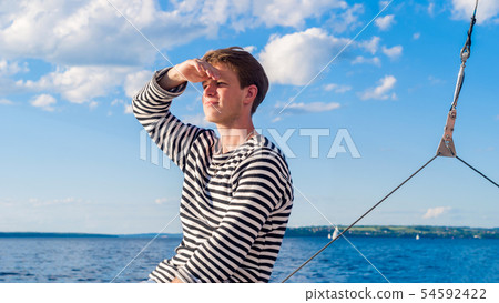 young male yachtsman looks into the distance young male yachtsman looks into the distance 54592422