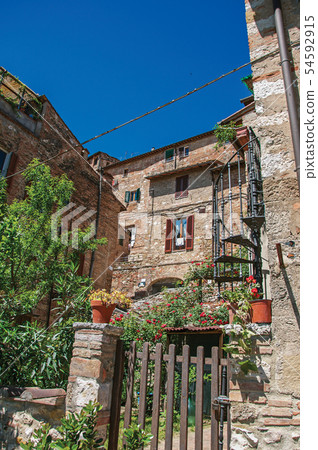 Wooden gate and old buildings with flowering 54592915